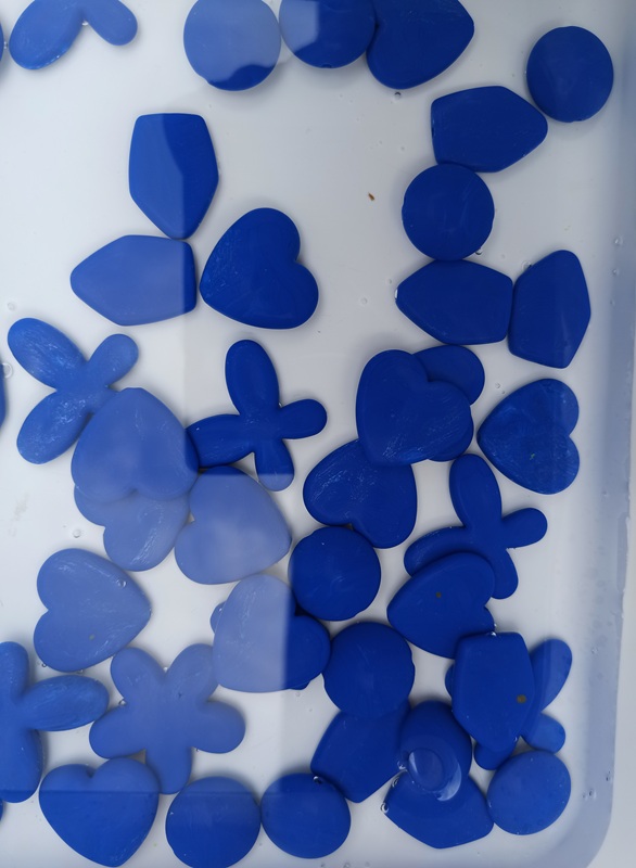acqua con piccoli fiori cuori e farfalle di plastica blu
