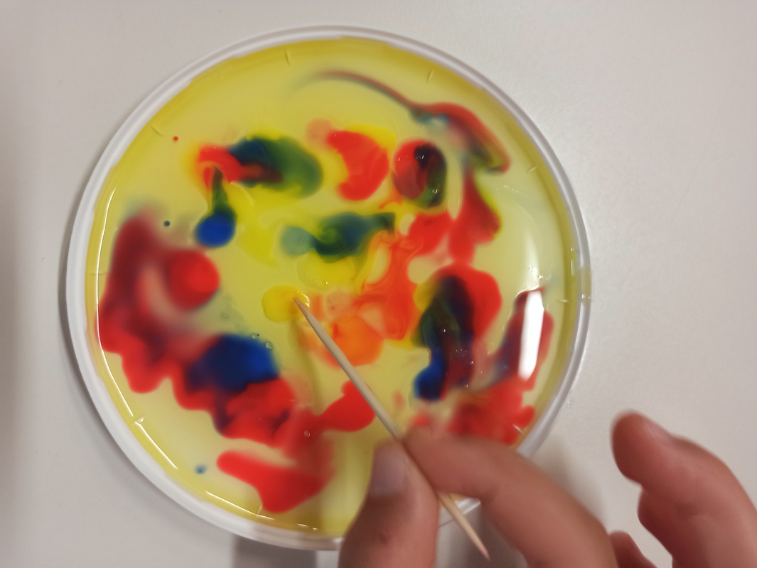 gocce colorate rotte con uno stuzzicadenti intinto nel sapone